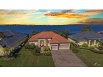Stunning waterfront home boasts lush landscaping, a brick driveway, and an inviting three-car garage at 2917 Mill Creek Rd, Port Charlotte, FL 33953