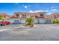 Inviting townhomes with neutral stucco, red tile roofs, shutters, driveways, and a lush tropical landscape create curb appeal at 240 W End Dr # 312, Punta Gorda, FL 33950