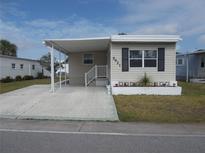 Charming home featuring a covered carport, decorative accents, and a well-maintained lawn at 5421 Holiday Park Blvd, North Port, FL 34287