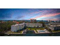 Waterfront condo building boasts boat docks, lush landscaping, and a sparkling pool for residents to enjoy at 600 Sutton Pl # 101B, Longboat Key, FL 34228