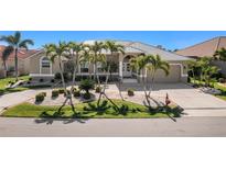 Beautiful single-story home with a lush lawn and palm trees in a well-maintained neighborhood at 1311 Pine Siskin Dr, Punta Gorda, FL 33950