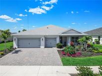 Charming single-story home with a three-car garage and meticulously maintained landscaping with palm trees at 16064 Shoreline Dr, Punta Gorda, FL 33982