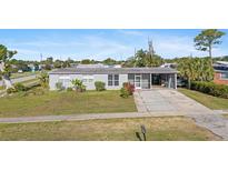 Charming single-story home with a well-maintained lawn, covered carport, and a welcoming screened entry at 2201 Birchcrest Blvd, Port Charlotte, FL 33952