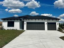 Beautiful single-story home featuring a three-car garage and a well-manicured front lawn at 5110 Burri Ct, North Port, FL 34288