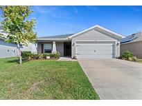 Charming single-story home with well-maintained lawn and a two-car garage on a sunny day at 6315 164Th E Ave, Parrish, FL 34219