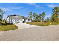 Charming single-story home features a two-car garage, a well-manicured lawn, and a concrete driveway at 3297 Swanee Rd, Punta Gorda, FL 33980
