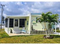Charming home featuring a lovely patio with rocking chairs, tropical landscaping, and a delightful nautical theme at 354 Blackburn Blvd, North Port, FL 34287
