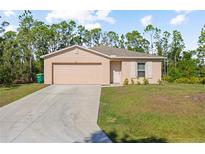 Charming single-story home with a well-maintained lawn and attached two-car garage at 401 Calendar St, Port Charlotte, FL 33954