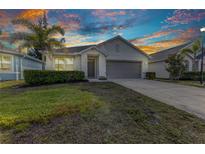 Charming single-story home featuring well-kept landscaping, palm tree, and a two-car garage at 25340 E Lenox Cir, Punta Gorda, FL 33950