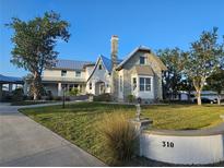 Charming two-story home with landscaped front yard and stone accents under a clear blue sky at 310 Severin Se Rd, Port Charlotte, FL 33952
