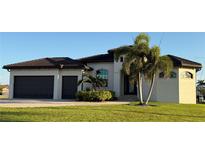 Beautiful one story home with a two car garage, tile roof, palm trees, and verdant lawn at 3414 Sandpiper Dr, Punta Gorda, FL 33950