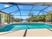Inviting screened-in pool area with a view of the canal, perfect for relaxation and entertainment at 4053 Joseph St, Port Charlotte, FL 33948