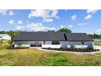 Beautiful one-story home features fresh landscaping and a well-manicured lawn, complementing the white exterior and dark roof at 5705 44Th E Ave, Bradenton, FL 34203