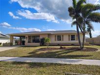 Charming single-story home with a well-maintained lawn, mature palms and a convenient covered carport at 6327 Fabian Rd, North Port, FL 34287