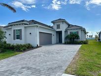 Beautiful one-story home featuring a paver driveway, two-car garage and manicured landscaping at 17420 Jadestone Ct, Venice, FL 34293