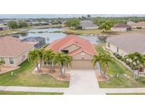 A beautiful aerial view of the house including a lake view and palm trees at 2699 Suncoast Lakes Blvd, Punta Gorda, FL 33980
