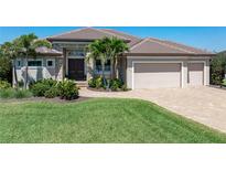 Charming single-story home with a paver driveway, mature landscaping, and a three-car garage at 2850 Magdalina Dr, Punta Gorda, FL 33950
