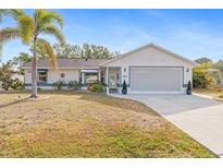 Charming single-story home with a well-maintained lawn, palm tree, and attached two-car garage at 3078 Mancini Ter, Punta Gorda, FL 33983