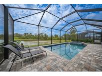 Relaxing screened pool and spa area with lounge chairs overlooking a beautiful nature preserve at 11359 Burgundy, Venice, FL 34293
