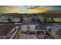 Stunning waterfront home featuring modern design with stone accents and a convenient covered parking area at 12387 Minot Ave, Port Charlotte, FL 33981