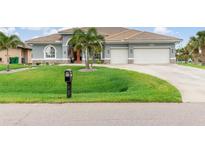 Charming single-story home featuring a spacious lawn, two-car garage, and a beautifully tiled roof at 15618 Aqua Cir, Port Charlotte, FL 33981