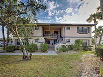Inviting exterior view of condo complex with mature landscaping and pedestrian walkway at 19505 Quesada Ave # Ee202, Port Charlotte, FL 33948