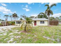 Charming single-story home with a light yellow exterior, a carport, and mature palm trees in the front yard at 217 Palm E Ave, Nokomis, FL 34275