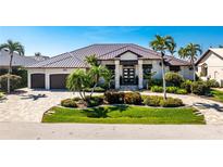 Stunning single-story home with a metal roof, manicured landscaping, and a circular driveway at 3657 Aruba Ct, Punta Gorda, FL 33950
