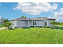 Charming single-story home with a well-manicured lawn and lush landscaping at 11456 5Th Ave, Punta Gorda, FL 33955