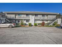 Two-story condo building featuring multiple units and parking spaces, surrounded by neat landscaping at 1211 Saxony Cir # B5, Punta Gorda, FL 33983