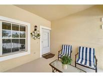 Inviting front porch with seating, decorative wreath, and secure storm door entry at 1235 Saxony Cir # 5202, Punta Gorda, FL 33983