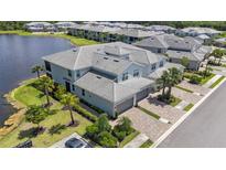 Stunning aerial view of a luxury townhome community on a lake with lush landscaping and paver driveways at 14617 Sycamore Ct # 2211, Punta Gorda, FL 33955