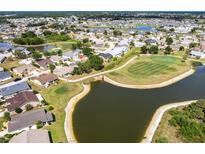 This aerial view shows a beautiful home overlooking a pond and the manicured greens of a golf course at 1872 Birmingham Blvd, Port Charlotte, FL 33980