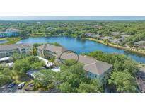 A panoramic view of the condo building surrounded by a lake and lush greenery at 19325 Water Oak Dr # 305, Port Charlotte, FL 33948