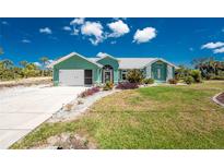 Charming single-story home with lush lawn, vibrant landscaping, and attached two-car garage at 2244 Meetze St, Port Charlotte, FL 33953