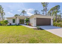 Charming single-story home with a well-manicured lawn, beautiful landscaping, and a two-car garage at 2300 Nordendale Blvd, North Port, FL 34288