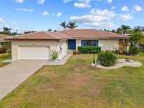 Charming single-story home with a well-manicured lawn, tasteful landscaping, and a two-car garage at 2310 El Cerito Ct, Punta Gorda, FL 33950