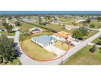New construction home boasts a well manicured lawn with lush surroundings and extended driveway in a quiet neighborhood at 24294 Santa Inez Rd, Punta Gorda, FL 33955
