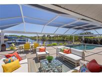 Relaxing screened lanai with plush seating, pool, canal views, and dining area perfect for entertaining at 4146 Library St, Port Charlotte, FL 33948