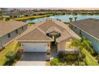 Inviting single-Gathering home featuring a neutral color scheme, well-manicured landscaping, and a picturesque lake in the backyard at 43839 Seedling Ter, Punta Gorda, FL 33982
