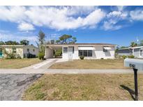 Charming single story home featuring a front lawn and a white exterior, complemented by a covered carport at 5179 Grobe St, North Port, FL 34287