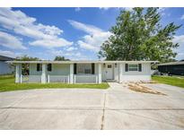Charming single-story home with a welcoming front porch and well-maintained landscaping at 654 Aqui Esta Dr, Punta Gorda, FL 33950