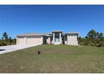 Charming single-story home featuring a three-car garage and well-manicured front lawn at 10071 Sunday Dr, Port Charlotte, FL 33981