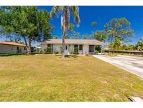 Charming single-story home with a well-maintained lawn and mature trees at 2690 Auburn Blvd, Port Charlotte, FL 33948