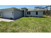 Charming single-story home featuring a well-maintained lawn and an attached two-car garage at 369 Biltmore St, Port Charlotte, FL 33953