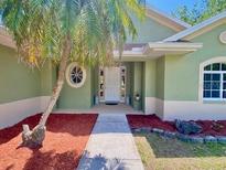 Charming single-story home with a decorative oval window and vibrant front yard landscaping at 3721 Adelaide Ave, North Port, FL 34288
