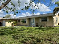 Charming one-story home with a well-maintained lawn and inviting double-door entryway at 705 Crestview Nw Cir, Port Charlotte, FL 33948