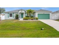 Charming one-story home with a well-manicured lawn, lush landscaping, and a two-car garage at 7434 Ashtabula St, Englewood, FL 34224
