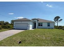 Beautiful single-story home with a well-maintained lawn and a two-car garage at 7474 Manville Ter, Port Charlotte, FL 33981