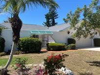Charming home featuring a gated front entrance, lush greenery, and a well-maintained lawn at 1305 Alton Rd, Port Charlotte, FL 33952